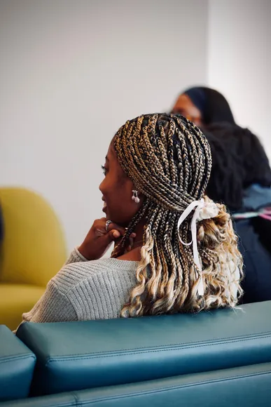 Attendee with blonde-tipped box braids tied back with a ribbon