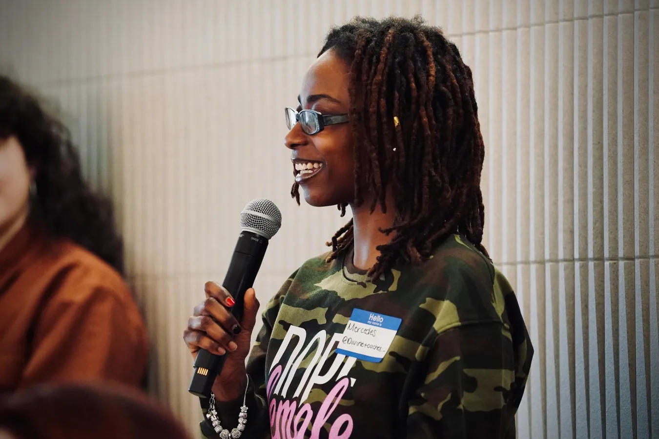 Attendee smiling while speaking into a microphone at a Braid event