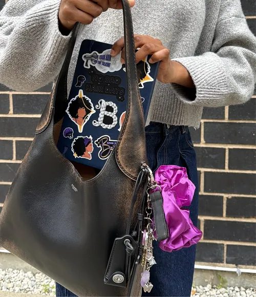 Braid stickers on a notebook tucked into a leather bag